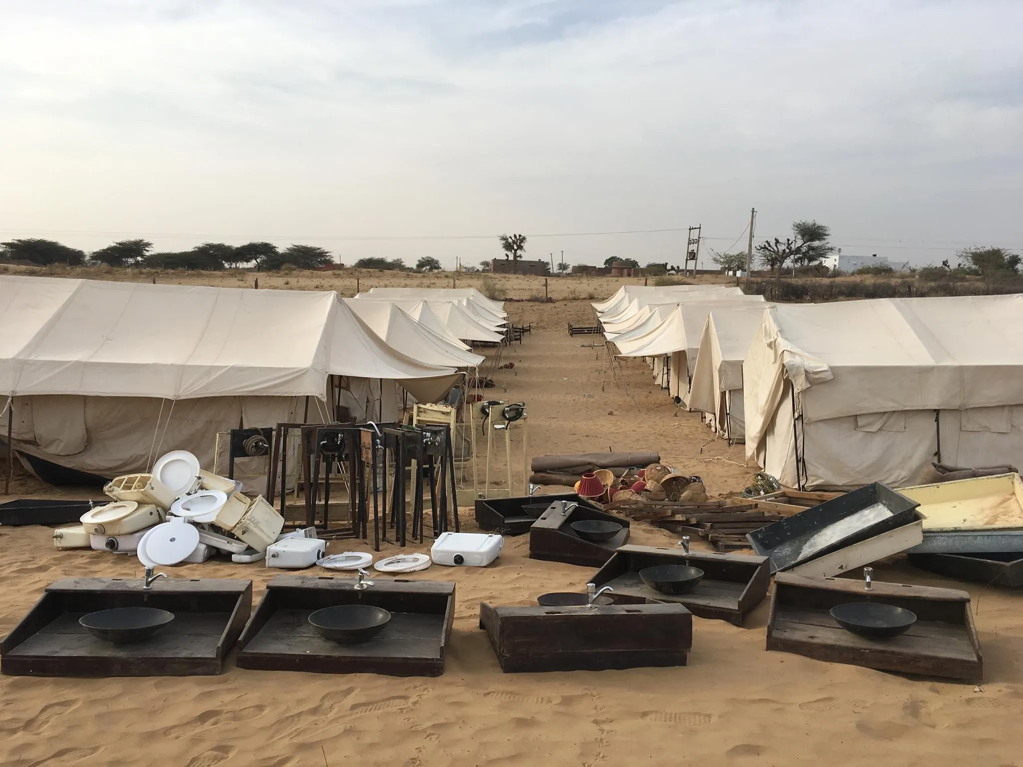 Luxury Swiss tents of a desert camp lit at dusk on the dunes